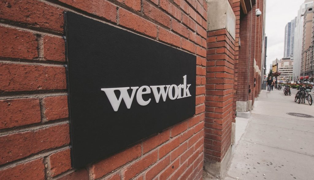 A WeWork sign. Photo by Eloise Ambursley on Unsplash 